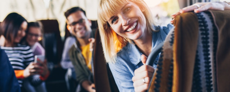 Smiling people and young girl on a Seattle charter bus rental